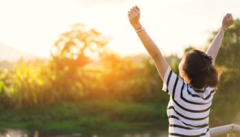 Woman finding relief from functional neurological disorder with happy arms in the air