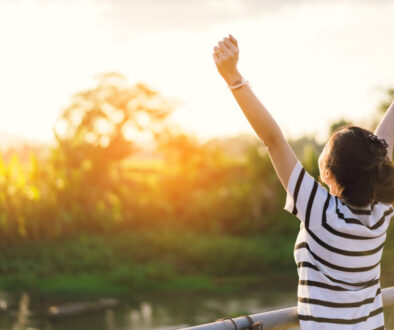 Woman finding relief from functional neurological disorder with happy arms in the air