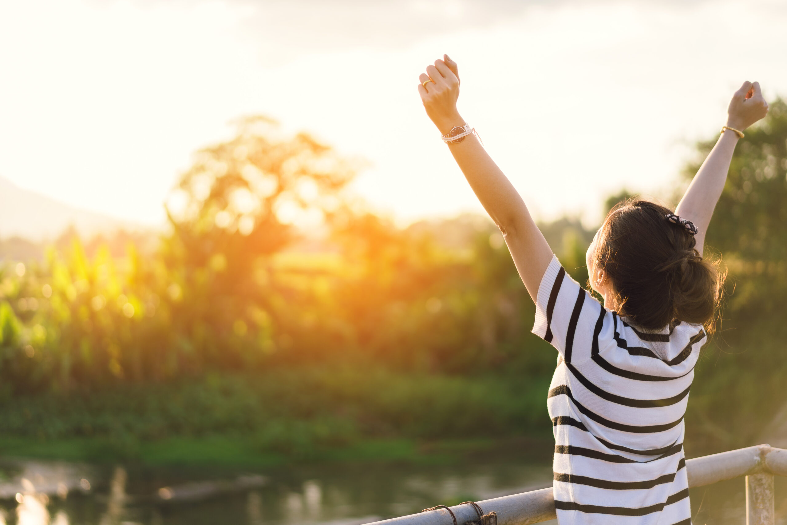 Woman finding relief from functional neurological disorder with happy arms in the air